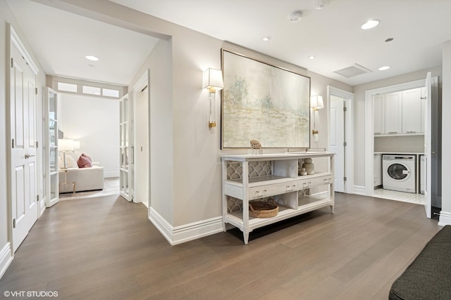 interior space with recessed lighting, washer / clothes dryer, baseboards, and wood finished floors