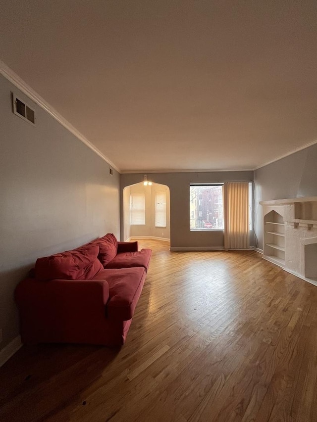 living room featuring a fireplace, hardwood / wood-style floors, and crown molding