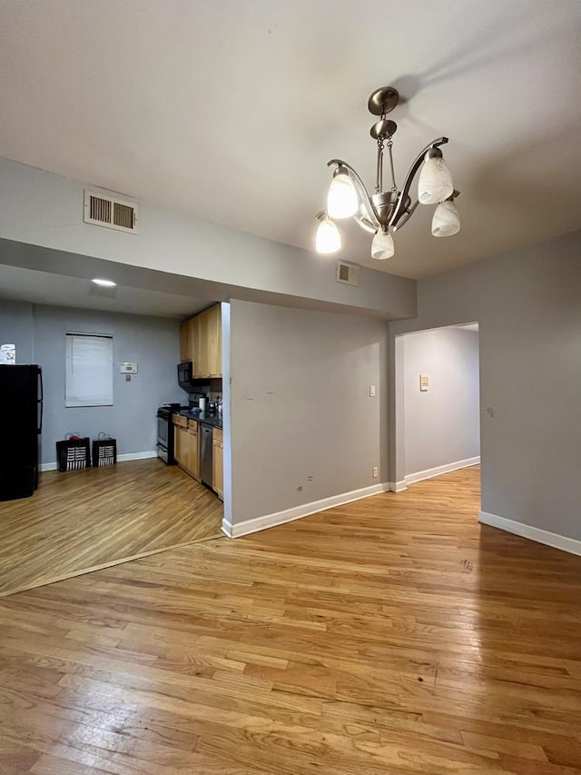 unfurnished living room with a chandelier and light hardwood / wood-style flooring