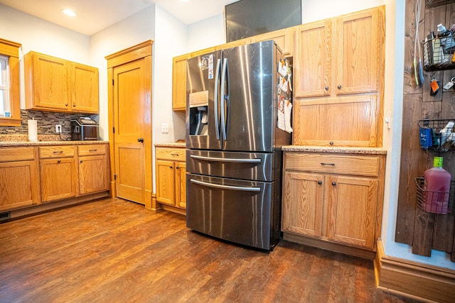 kitchen with decorative backsplash, stainless steel fridge with ice dispenser, dark hardwood / wood-style flooring, and light stone countertops