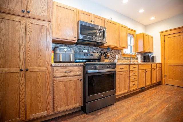 kitchen featuring appliances with stainless steel finishes, tasteful backsplash, dark hardwood / wood-style floors, and sink