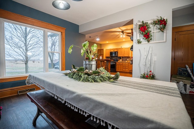 dining area with ceiling fan and dark hardwood / wood-style floors