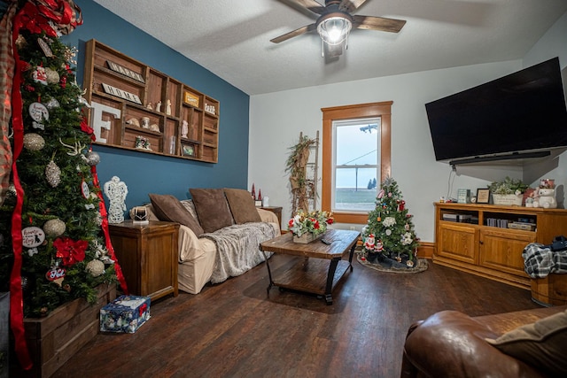 living room with a textured ceiling, ceiling fan, and dark hardwood / wood-style floors