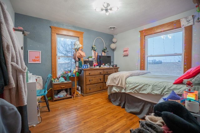 bedroom featuring hardwood / wood-style floors and a textured ceiling