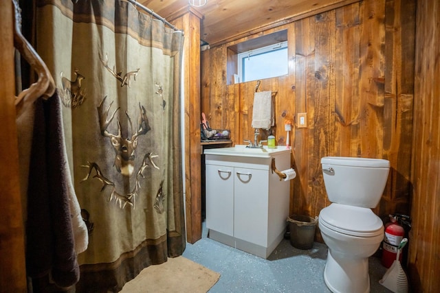 bathroom with vanity, toilet, wood ceiling, and wood walls