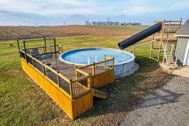 view of swimming pool featuring a yard and a rural view