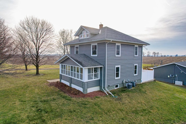 back of house with a sunroom, a yard, and central AC unit