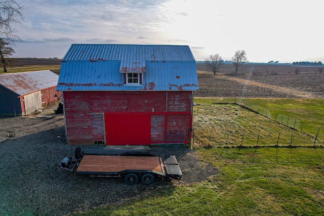 view of outbuilding with a lawn and a rural view