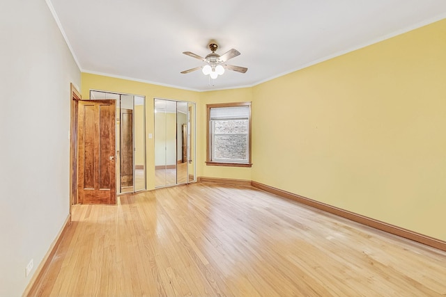 unfurnished bedroom with ceiling fan, crown molding, multiple closets, and light wood-type flooring