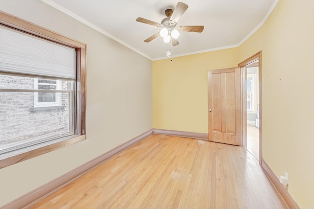 empty room featuring ornamental molding, plenty of natural light, and light wood-type flooring