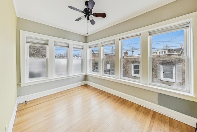 unfurnished sunroom with ceiling fan