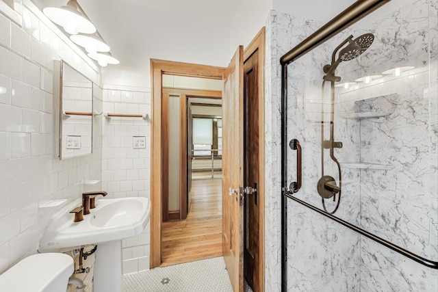 bathroom featuring tile walls, an enclosed shower, and toilet