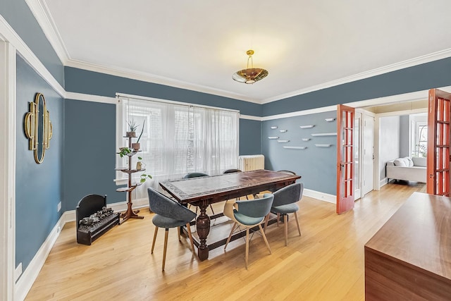 dining area featuring crown molding, radiator, and light hardwood / wood-style flooring