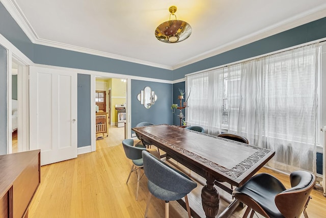 dining area with plenty of natural light, ornamental molding, and light wood-type flooring