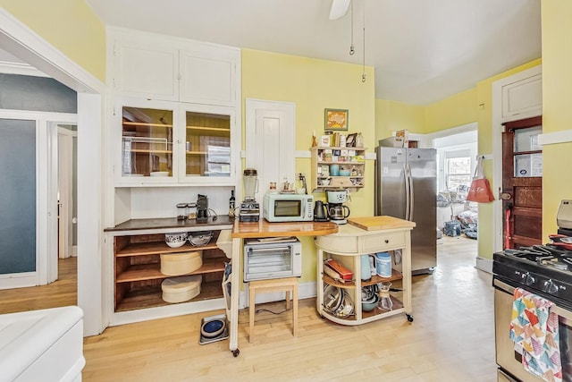 kitchen with white cabinetry, appliances with stainless steel finishes, wood counters, and light wood-type flooring