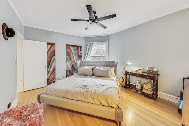 bedroom featuring crown molding, hardwood / wood-style flooring, and ceiling fan