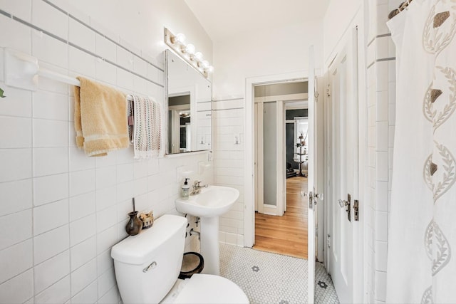 bathroom with tile walls, tile patterned flooring, and toilet