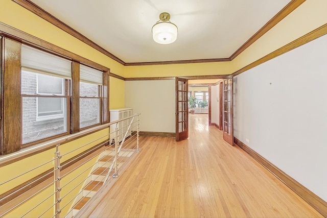 corridor with hardwood / wood-style floors, crown molding, and french doors