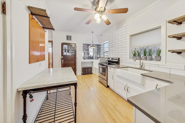 kitchen featuring pendant lighting, sink, radiator, white cabinetry, and stainless steel electric stove