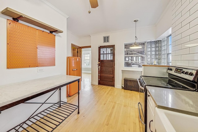 kitchen featuring crown molding, decorative light fixtures, radiator heating unit, electric stove, and light hardwood / wood-style floors