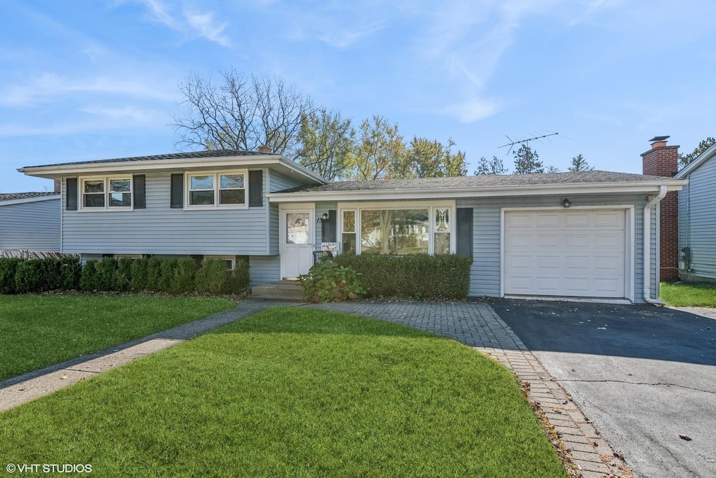 split level home with a front lawn and a garage