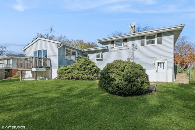 rear view of house featuring a deck and a lawn