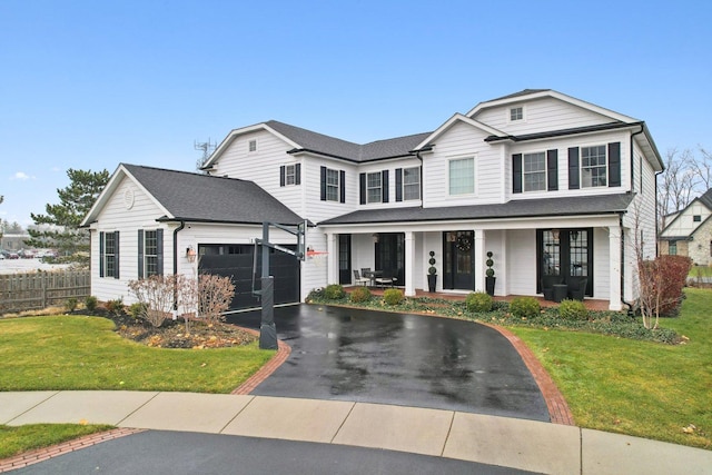 view of front facade with a front yard, a garage, and a porch