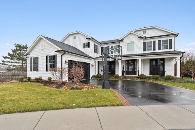 view of front facade with a garage, a porch, and a front yard