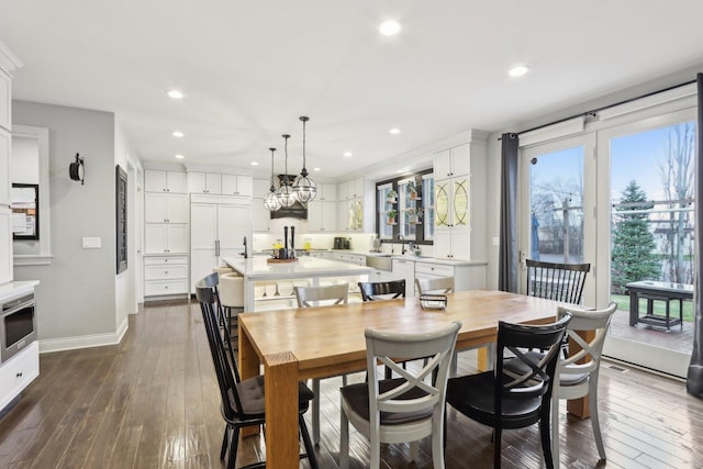 dining room featuring sink, dark hardwood / wood-style flooring, and plenty of natural light