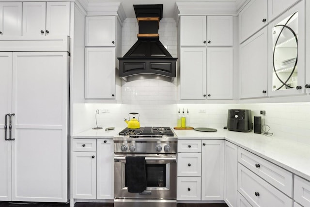 kitchen with white cabinets, custom exhaust hood, gas stove, and decorative backsplash