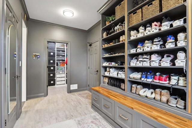 walk in closet with light hardwood / wood-style flooring