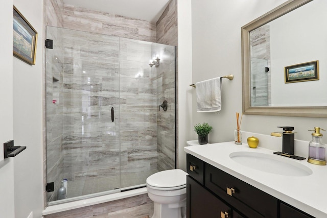 bathroom with toilet, vanity, and walk in shower