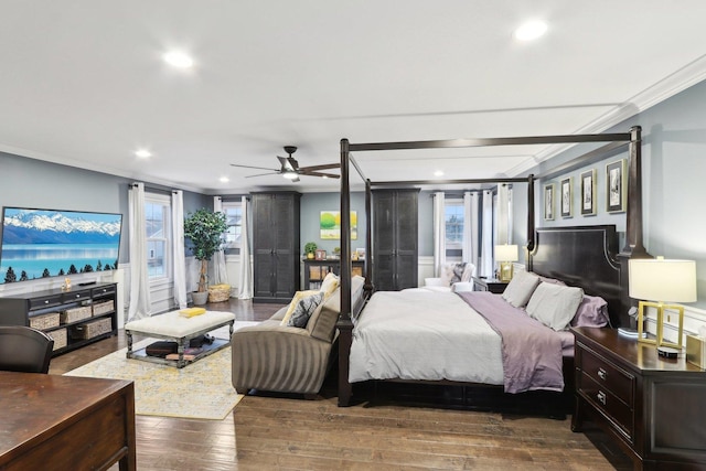 bedroom with ceiling fan, dark hardwood / wood-style flooring, ornamental molding, and multiple windows