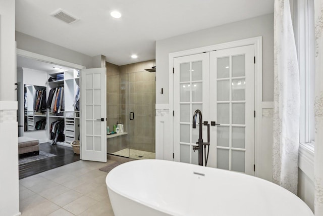 bathroom with independent shower and bath, french doors, and tile patterned floors