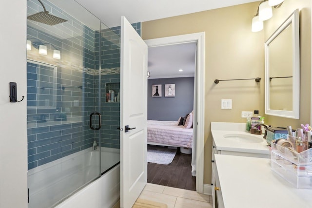 bathroom with tile patterned flooring, enclosed tub / shower combo, and vanity