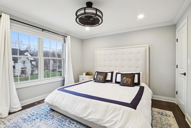 bedroom with crown molding and dark hardwood / wood-style floors