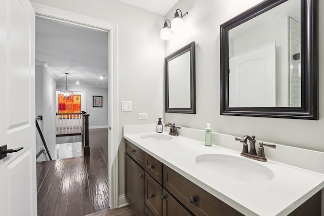 bathroom featuring vanity, an inviting chandelier, hardwood / wood-style flooring, and crown molding