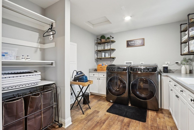 laundry room featuring separate washer and dryer, light hardwood / wood-style flooring, and sink