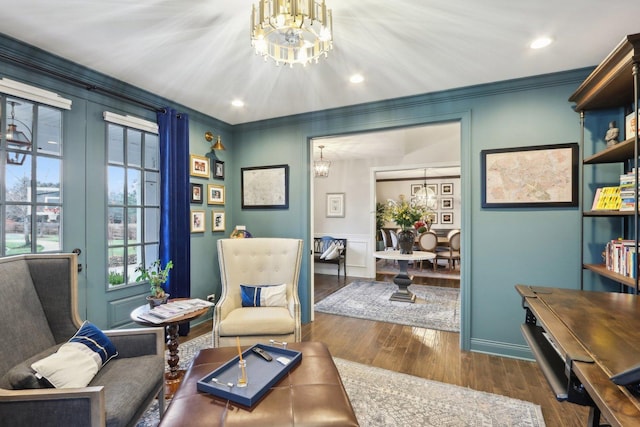 living area featuring french doors, ornamental molding, a notable chandelier, and dark wood-type flooring