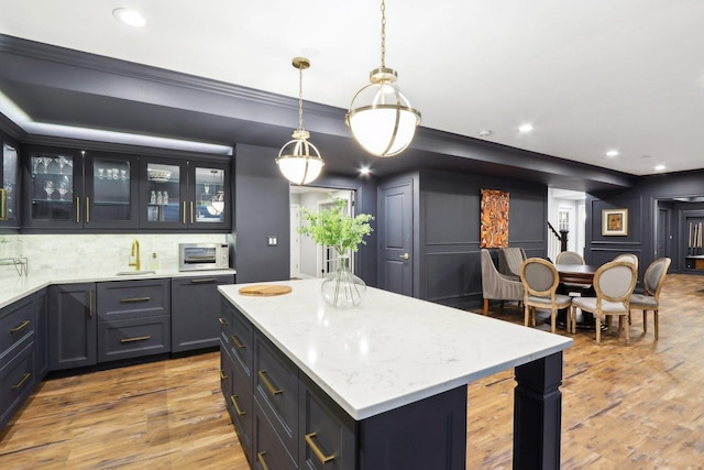 kitchen featuring sink, decorative light fixtures, a center island, dishwasher, and decorative backsplash