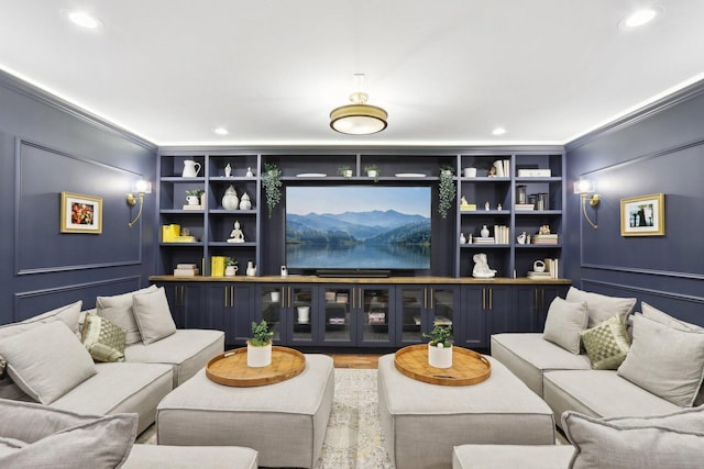 living room with wood-type flooring, crown molding, and built in features