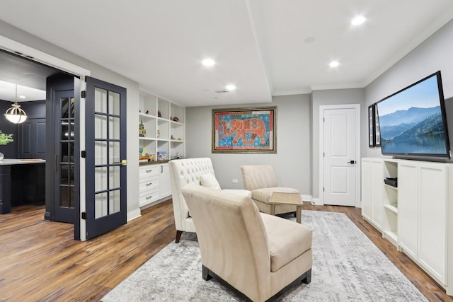 living area with french doors, hardwood / wood-style floors, and built in features