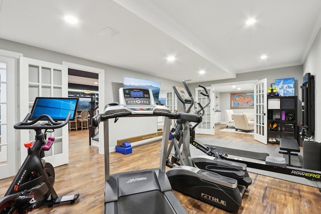 exercise room featuring ornamental molding, light hardwood / wood-style flooring, and french doors