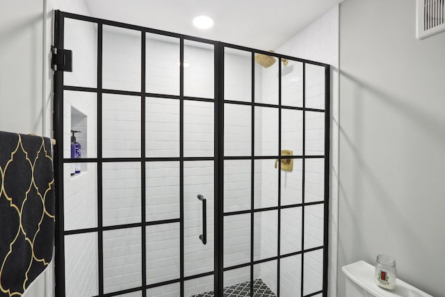 interior details featuring a tile shower and toilet