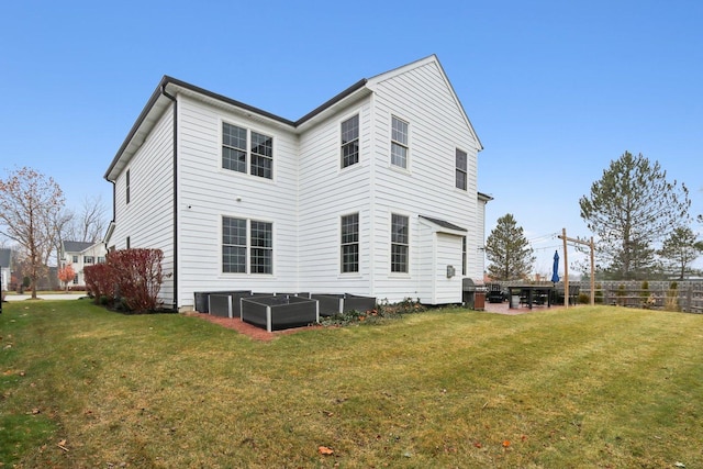 rear view of house featuring central air condition unit and a lawn