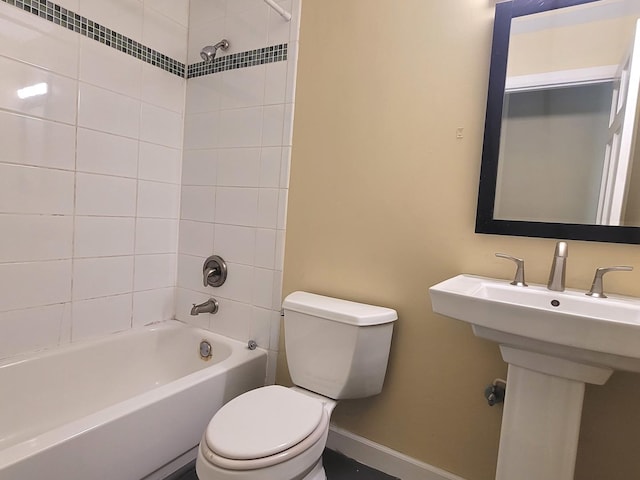 bathroom with tiled shower / bath combo and toilet