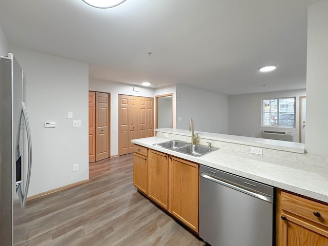 kitchen with sink, appliances with stainless steel finishes, and light hardwood / wood-style flooring