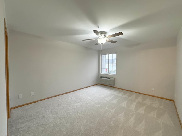 unfurnished room with light colored carpet, a wall unit AC, and ceiling fan