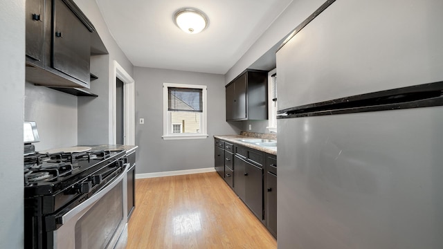 kitchen featuring stainless steel refrigerator, range with gas cooktop, and light hardwood / wood-style floors