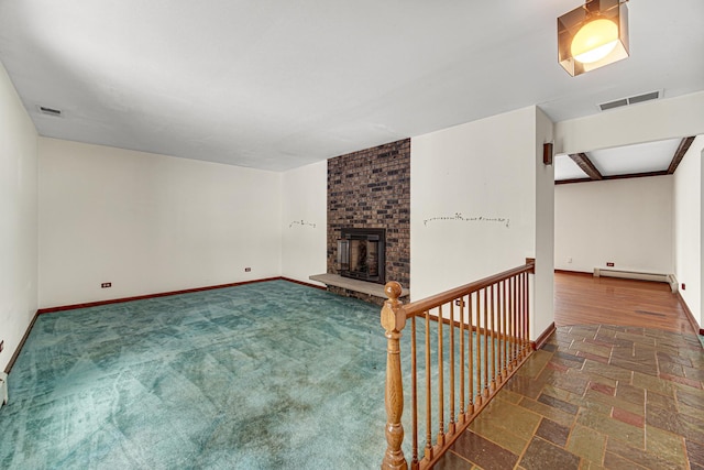 unfurnished living room with a baseboard radiator, a brick fireplace, and beam ceiling